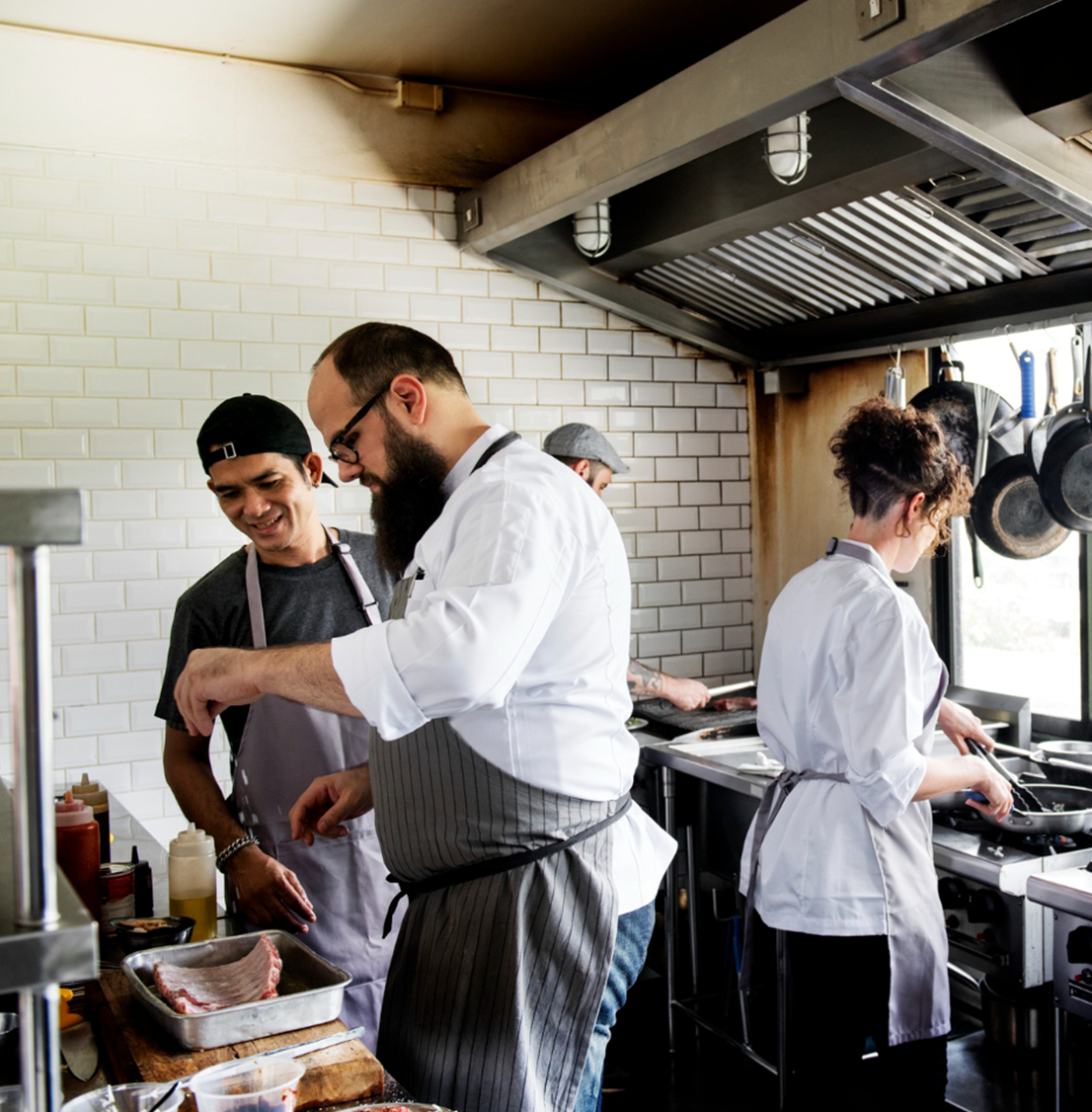 Chefs and waiters inside a working kitchen